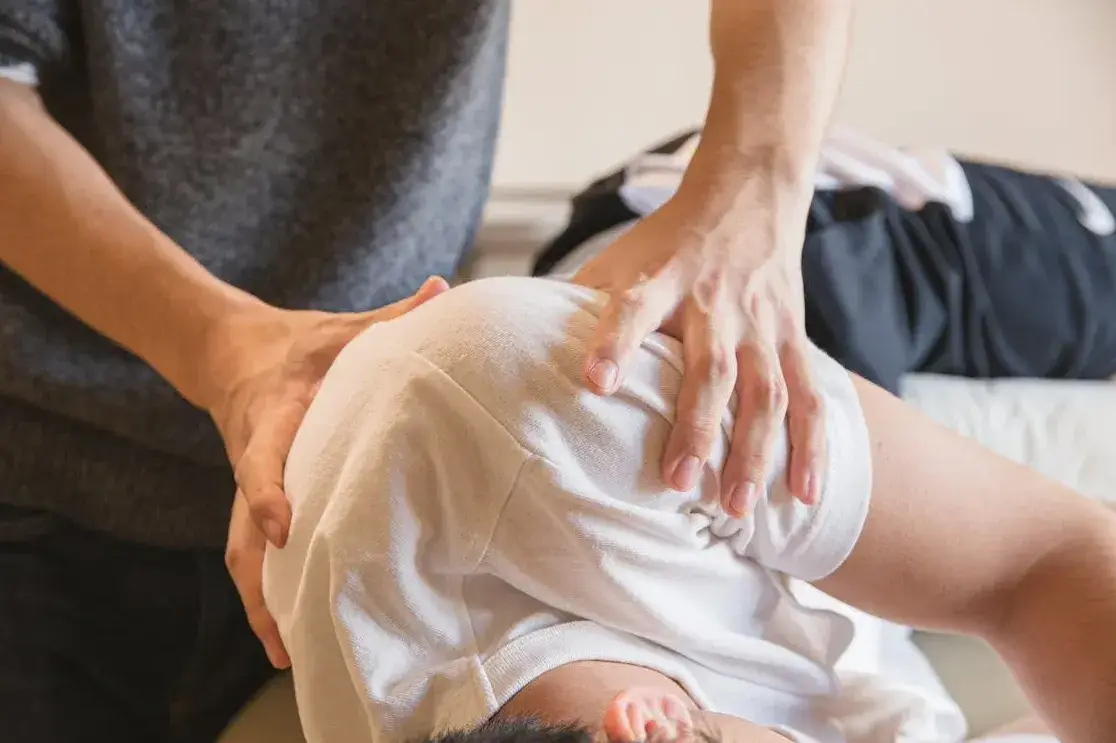 Chiropractor performing a manual adjustment on a patient's back. 