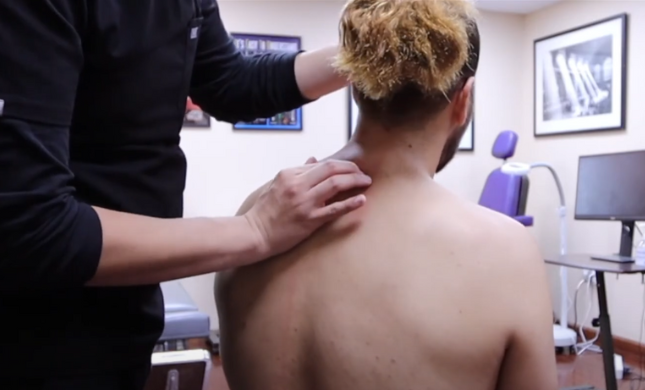 Chiropractor applying hands-on treatment to a patient’s neck and shoulders. 