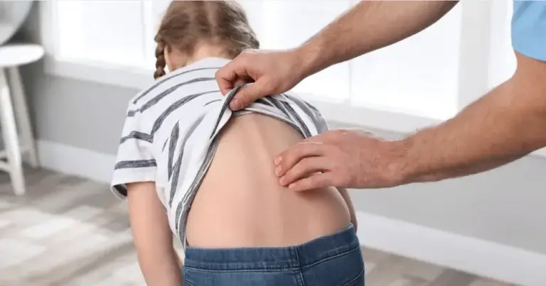 Chiropractor examining a young girl's spine for scoliosis treatment in 2025.