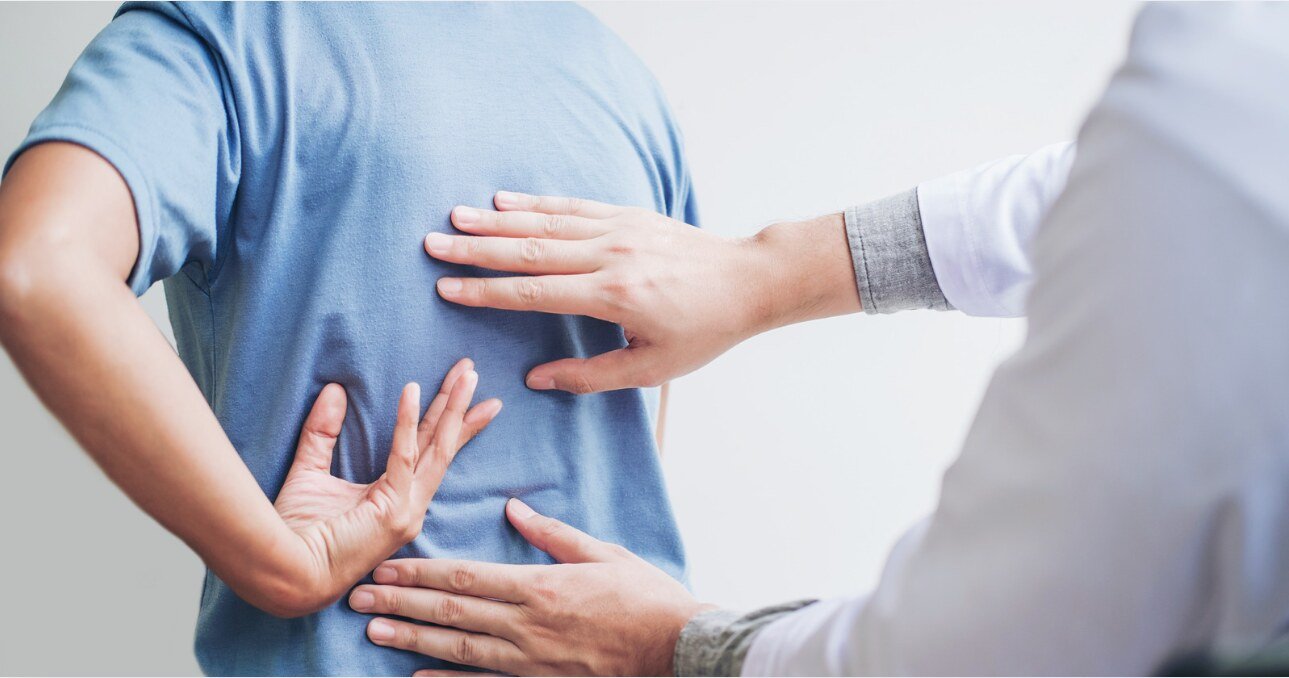 Chiropractor assessing a patient’s lower back pain.